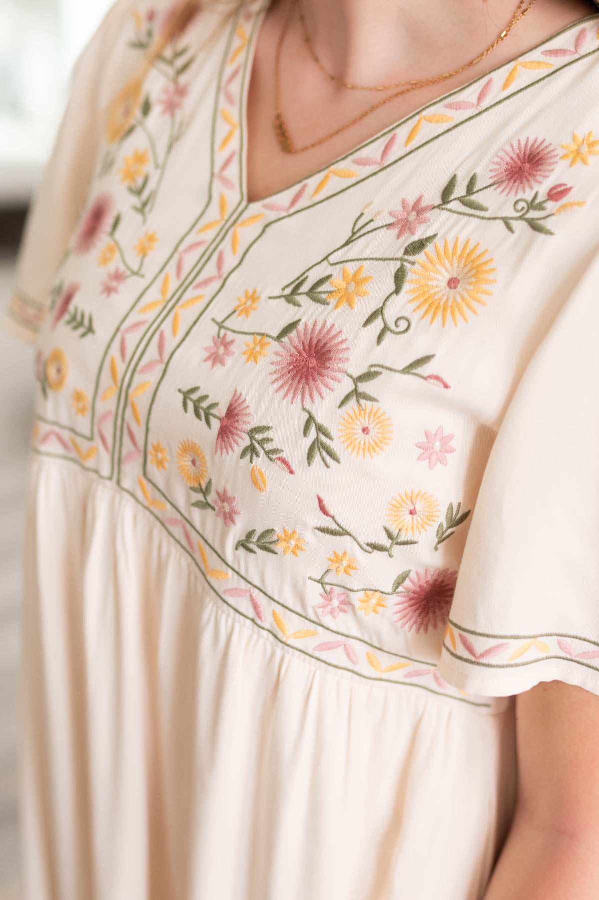 Close up of the embroidery on the cream embroidered dress