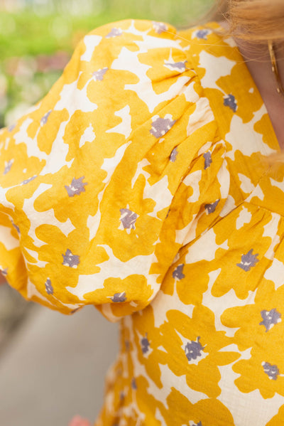 Close up of the fabric of the mustard floral dress