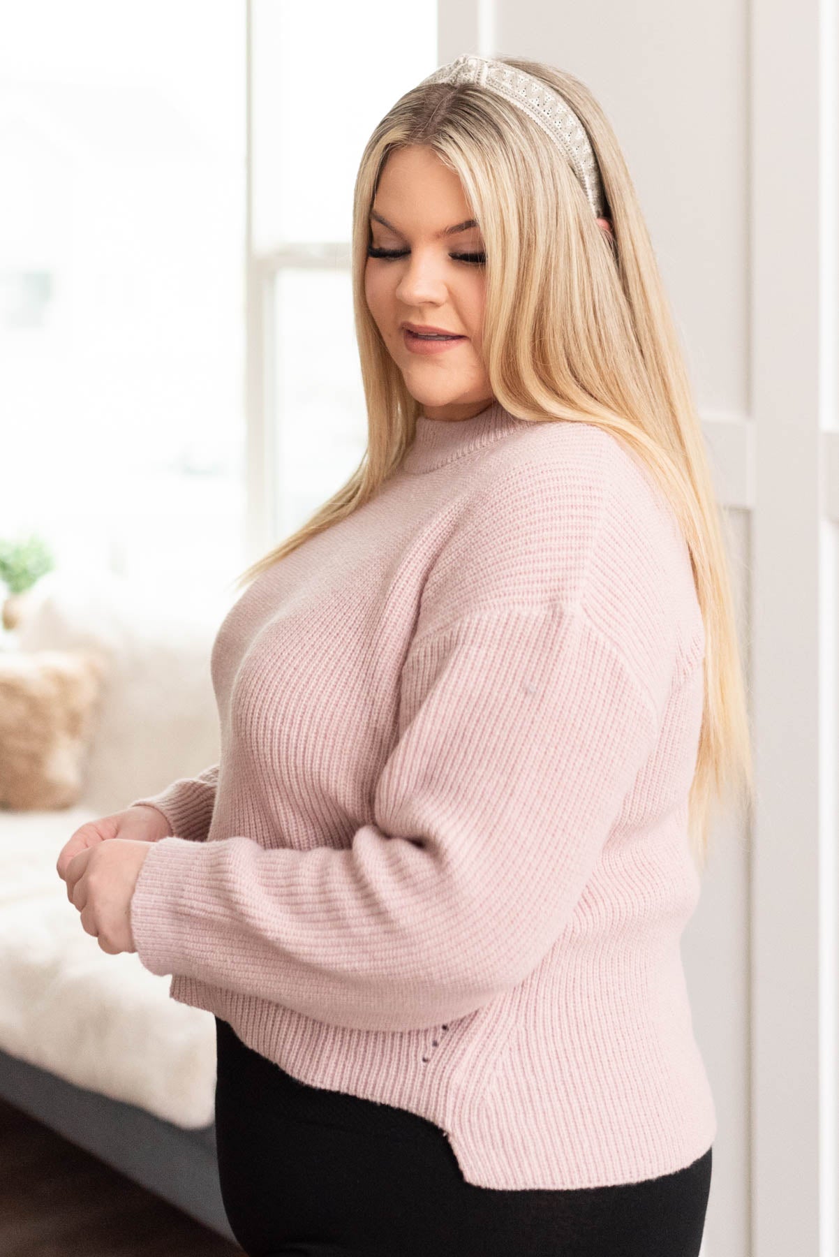 Side view of a blush knit sweater in plus size
