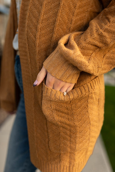 knit pattern and pocket on a mustard cardigan