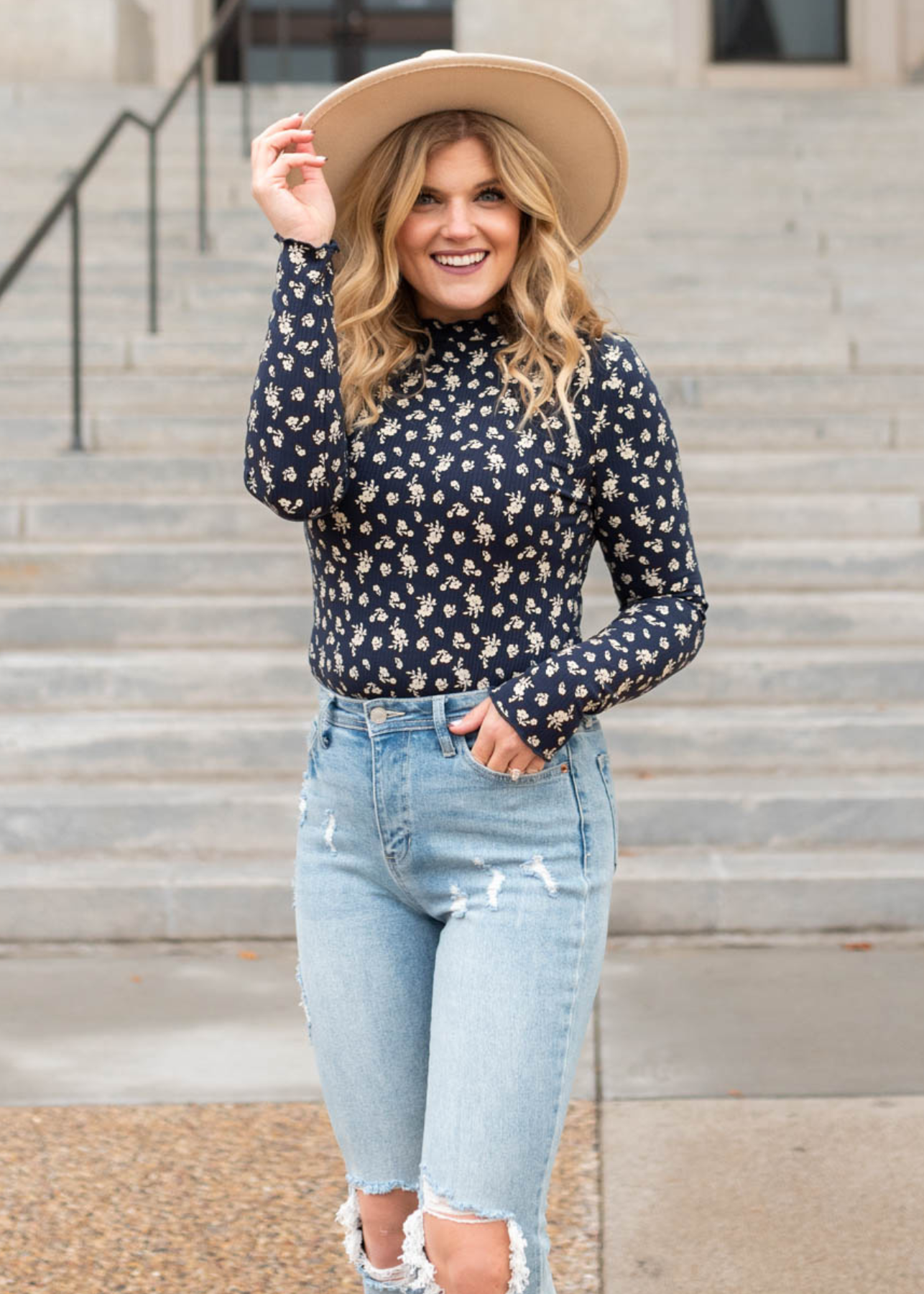 Front view of a navy flower print long sleeve top