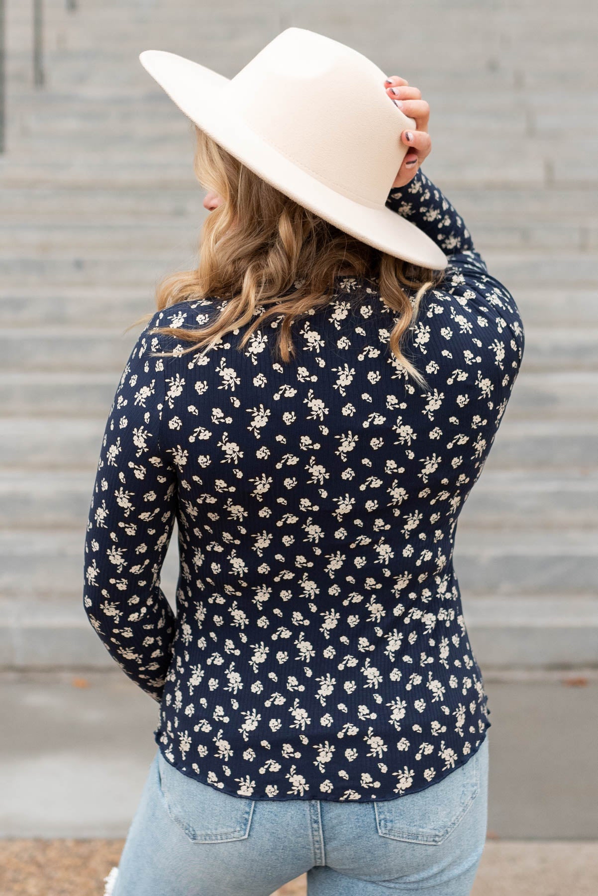Back view of a navy flower print long sleeve top