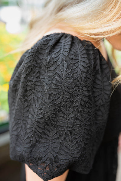 Close up of the lace on the black lace square neck dress