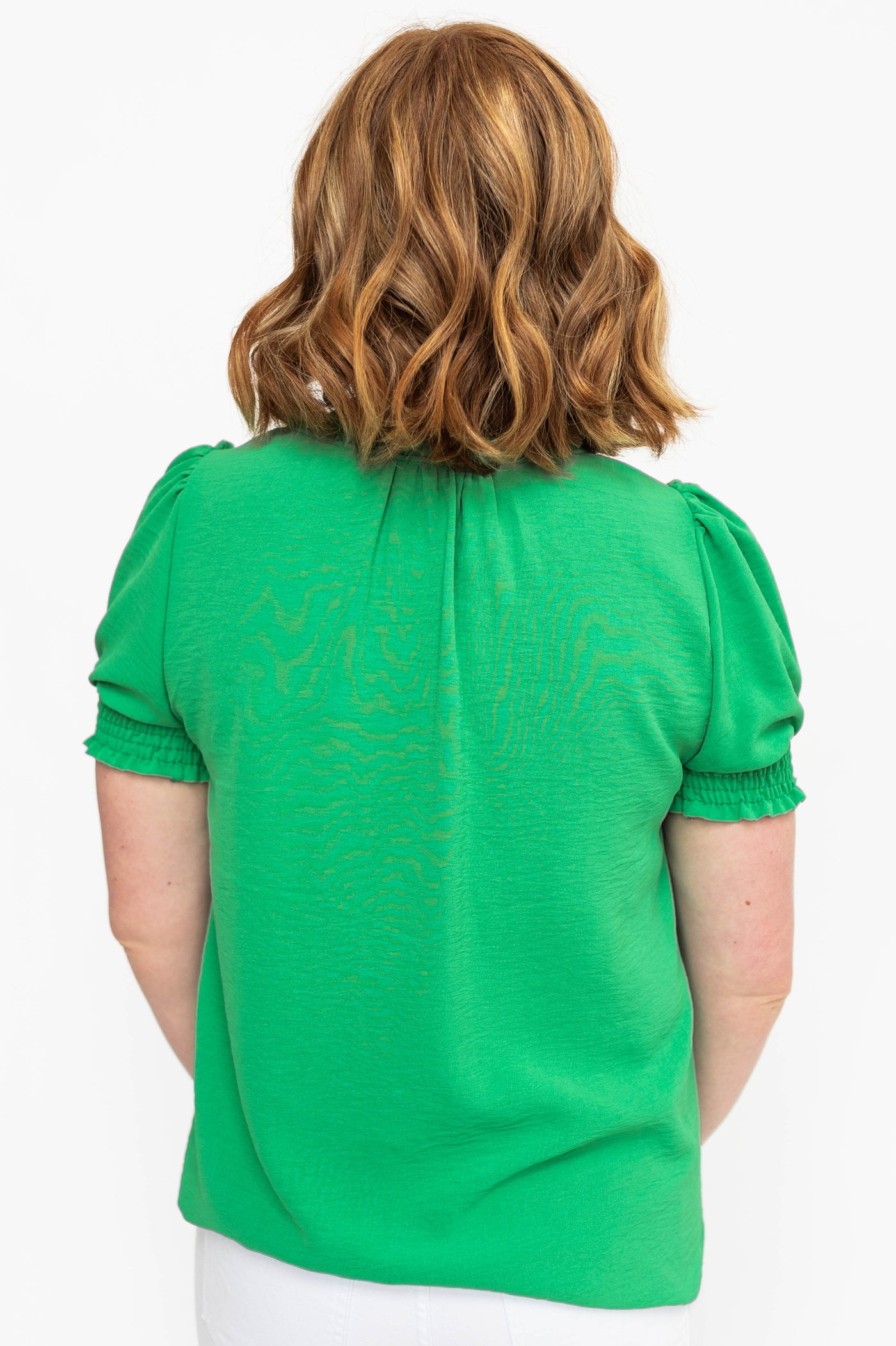 Back view of a kelly green top with open at neck