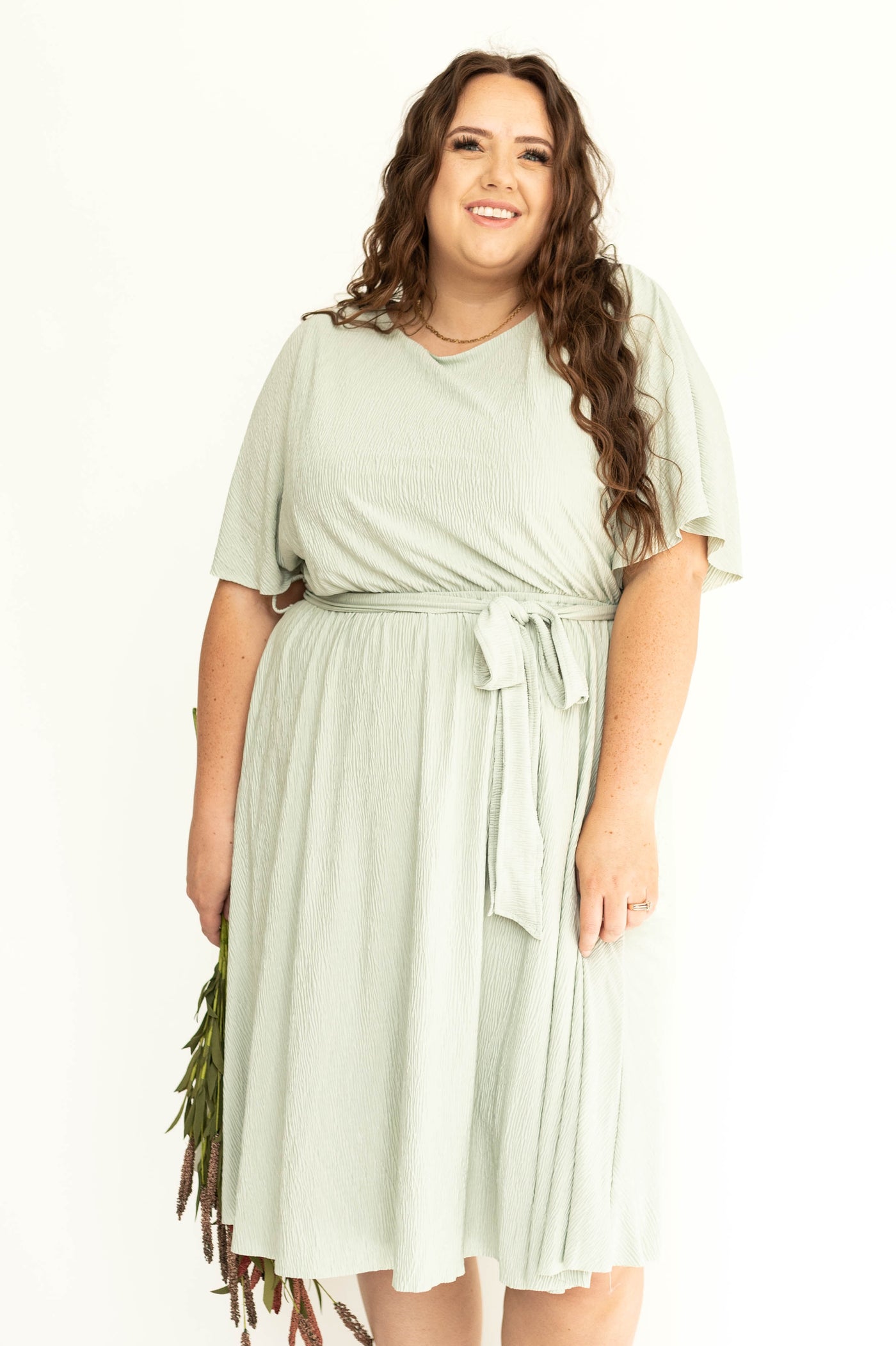 Front view of a sage colored plus size dress
