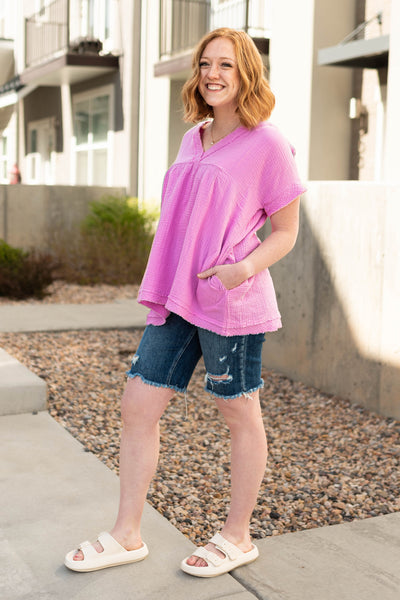 Front view of a mauve short sleeve top with a v-neck and pockets