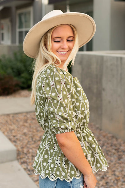 Side view of a short sleeve olive floral top