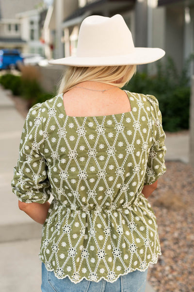 Back view of a short sleeve olive floral top