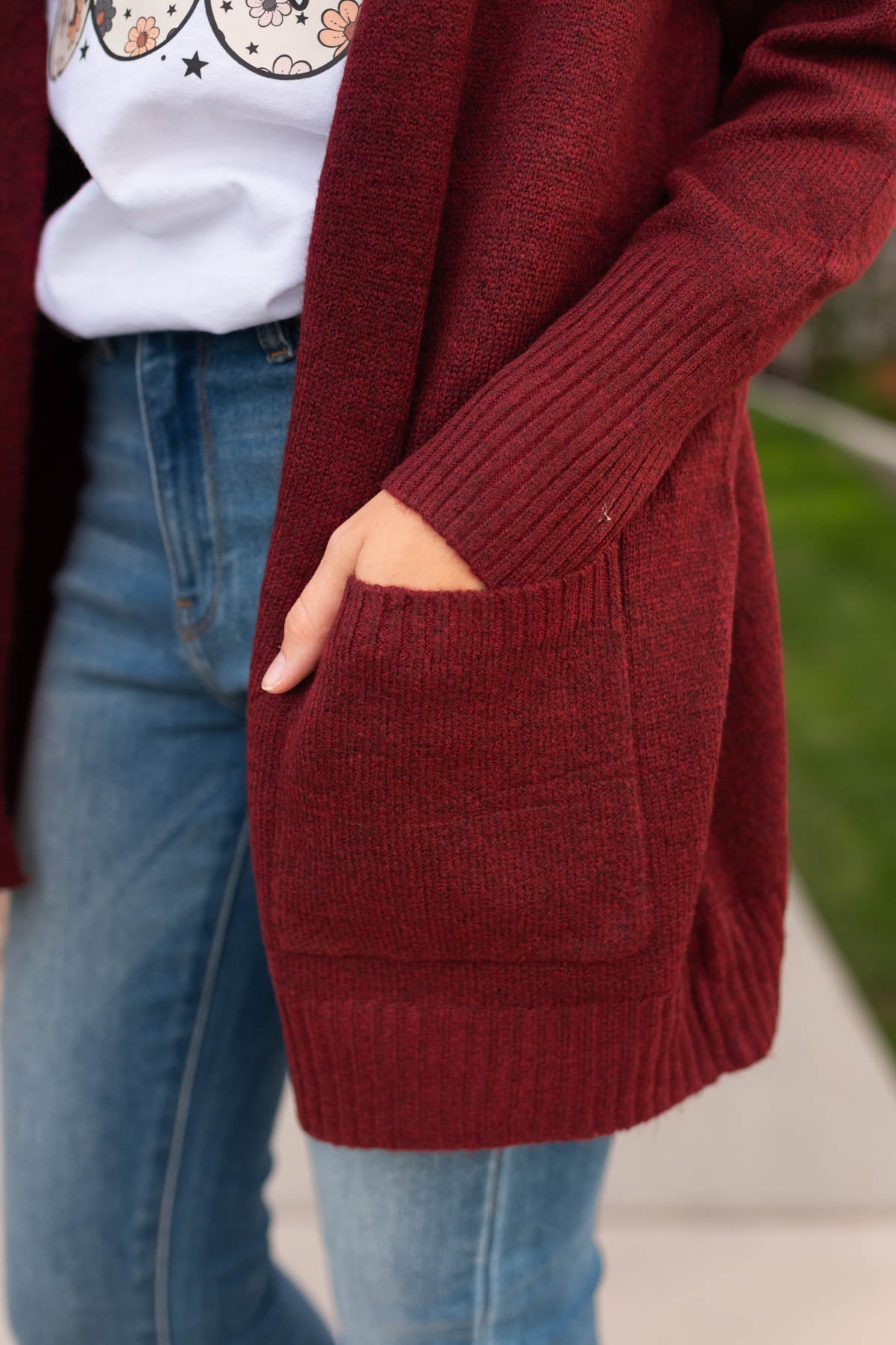 Close up of the pocket on a burgundy cardigan