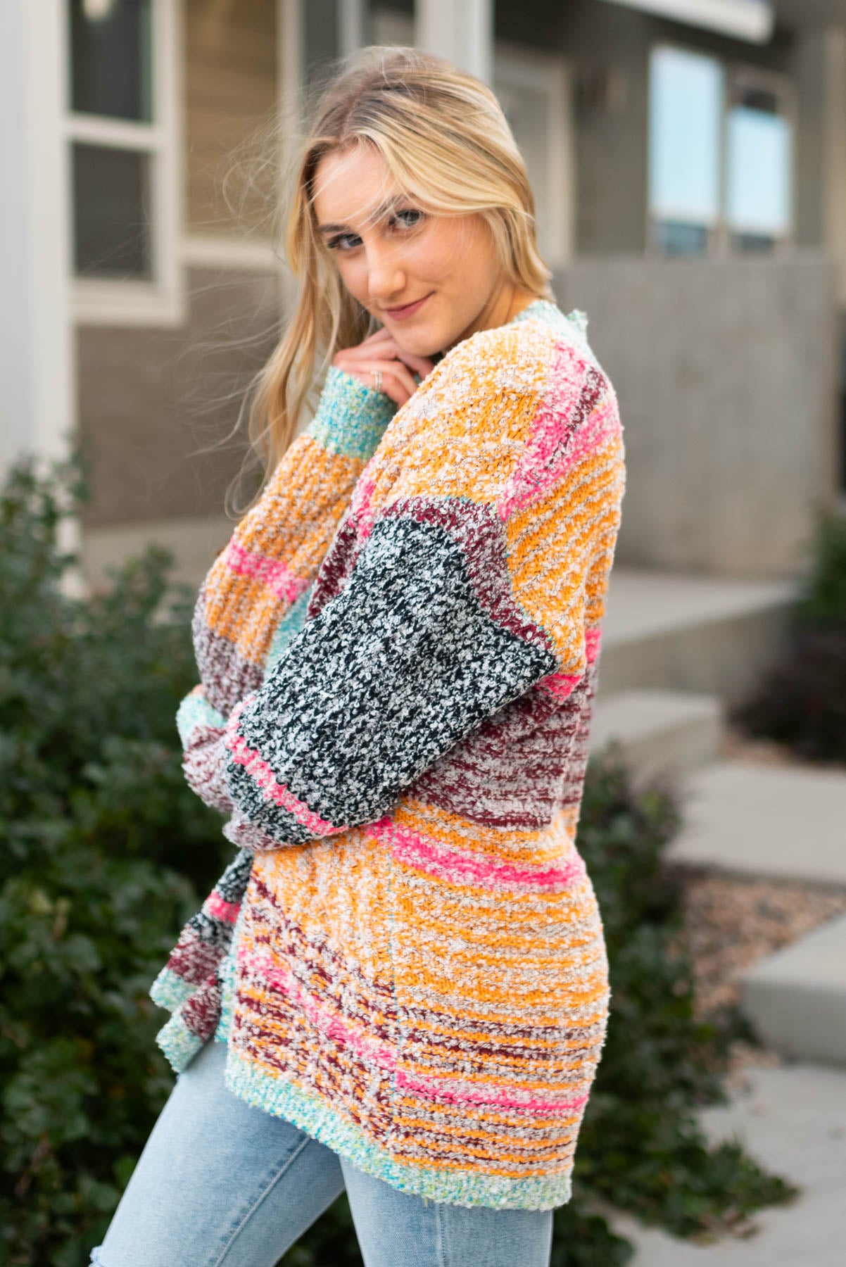 Side view of a multi knit open cardigan
