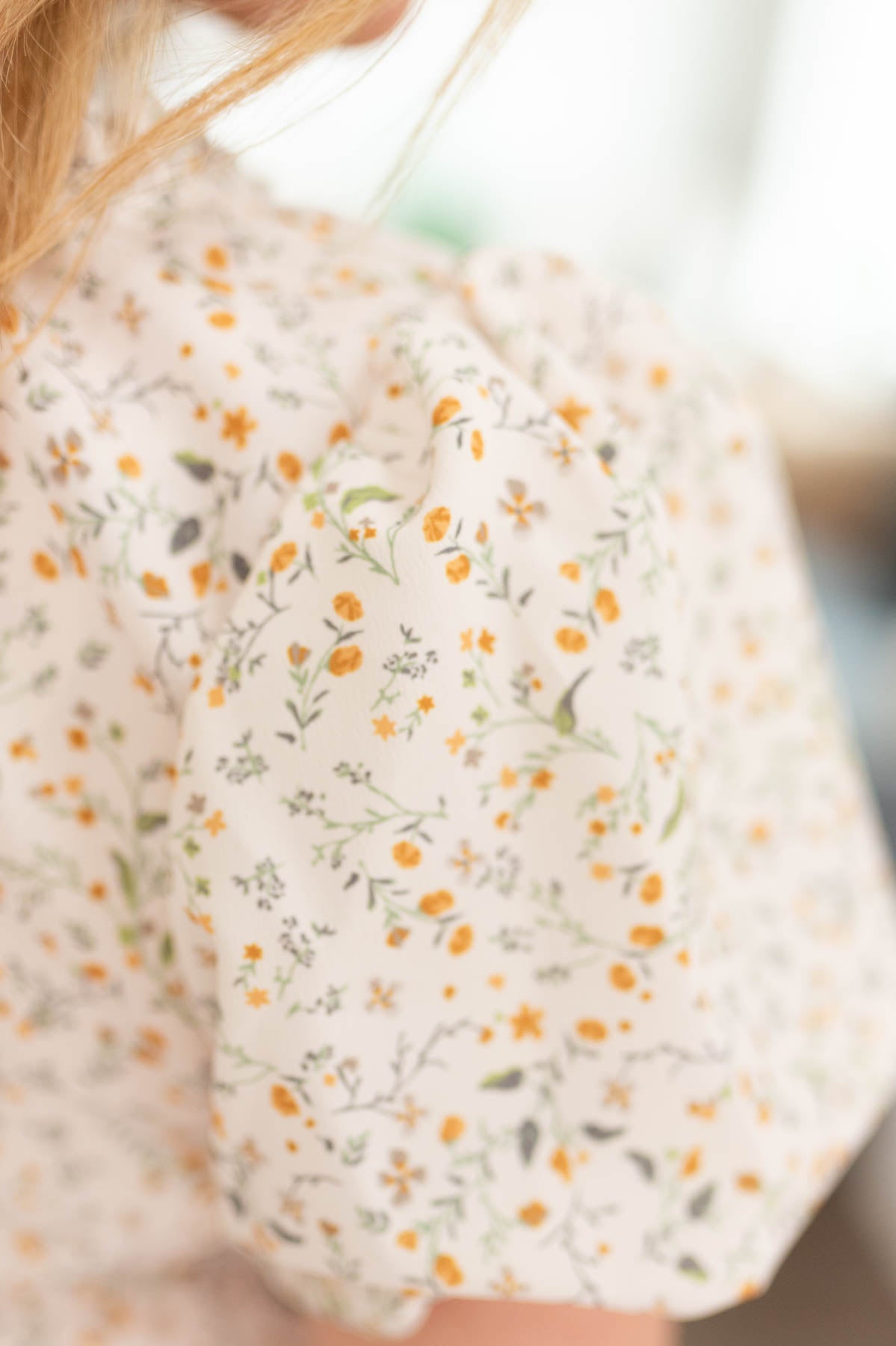 Close up of the sleeve and fabric on the cream floral printed blouse