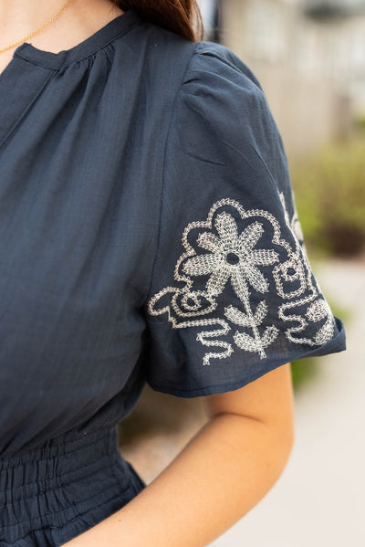 Close up of the embroidery on the navy embroidered detail dress