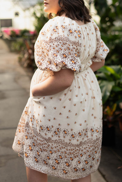 Side view of the plus size beige daisy dress with pockets