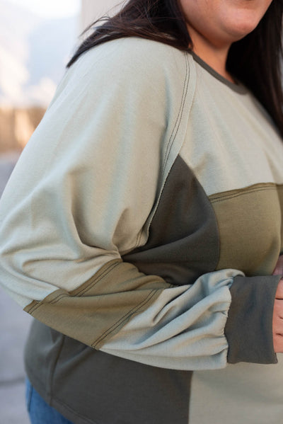 Close up of the sleeve on a plus size olive block sweater