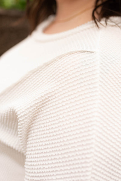 Close up of the fabric on the plus size white ribbed knit top