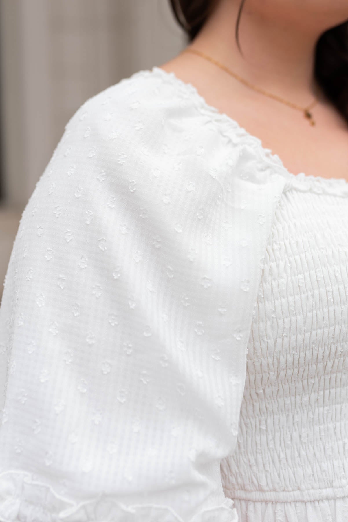 Close up of the sleeve on a white tiered textured dress