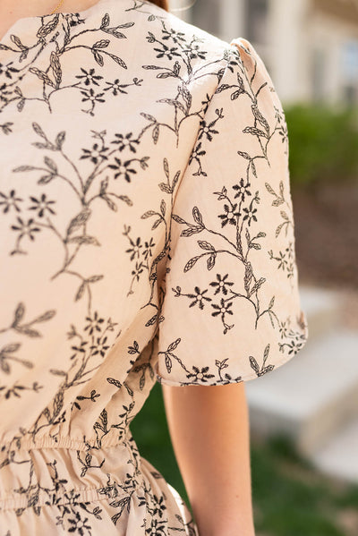 Close up of the sleeve on the taupe patterned dress