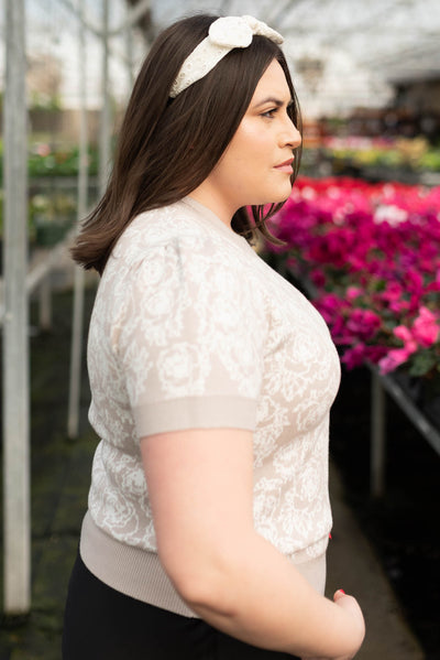 Side view of the plus size taupe floral knit top
