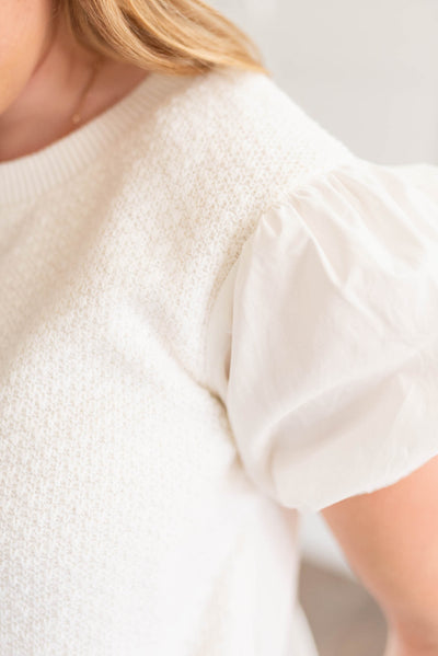 Close up of the fabric and sleeve on the off white blouse