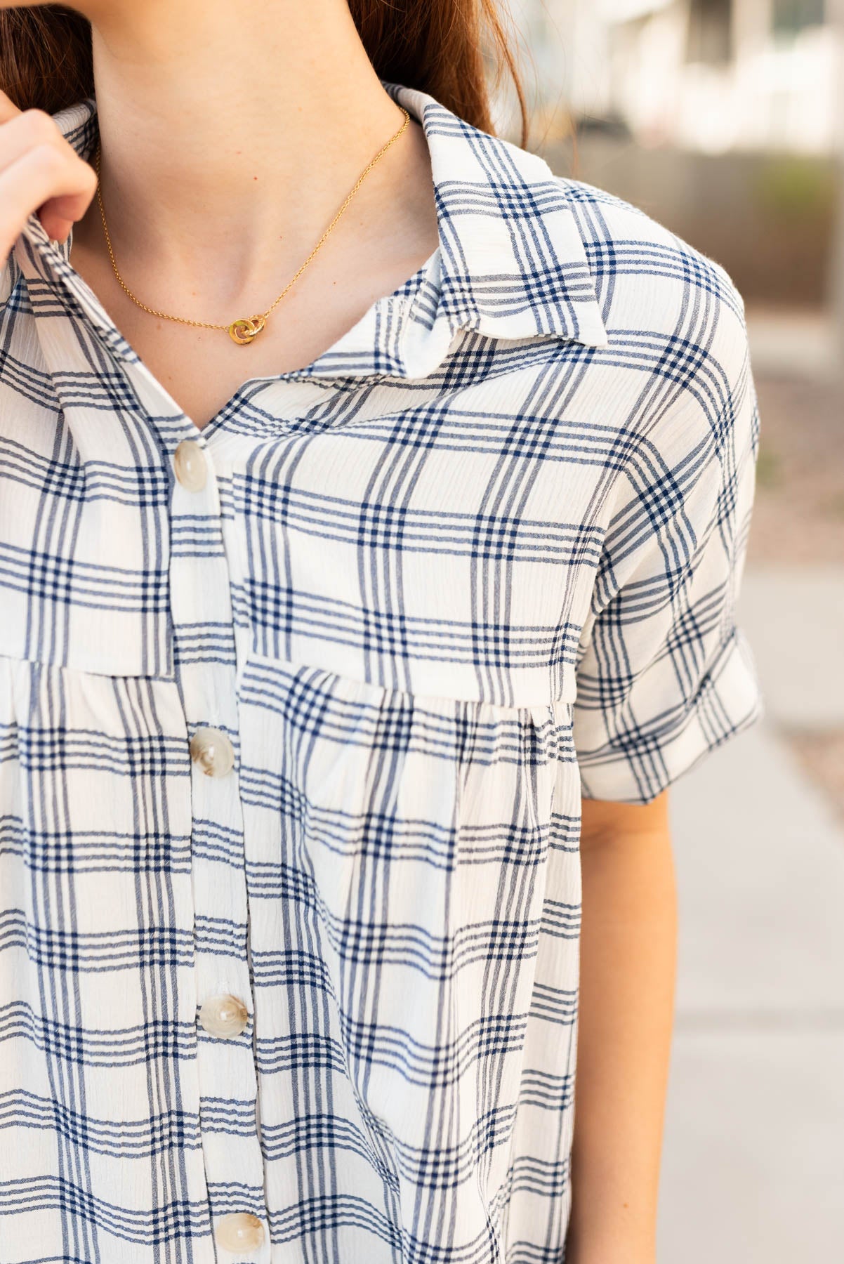 Close up of the fabric and sleeves on the navy button down top