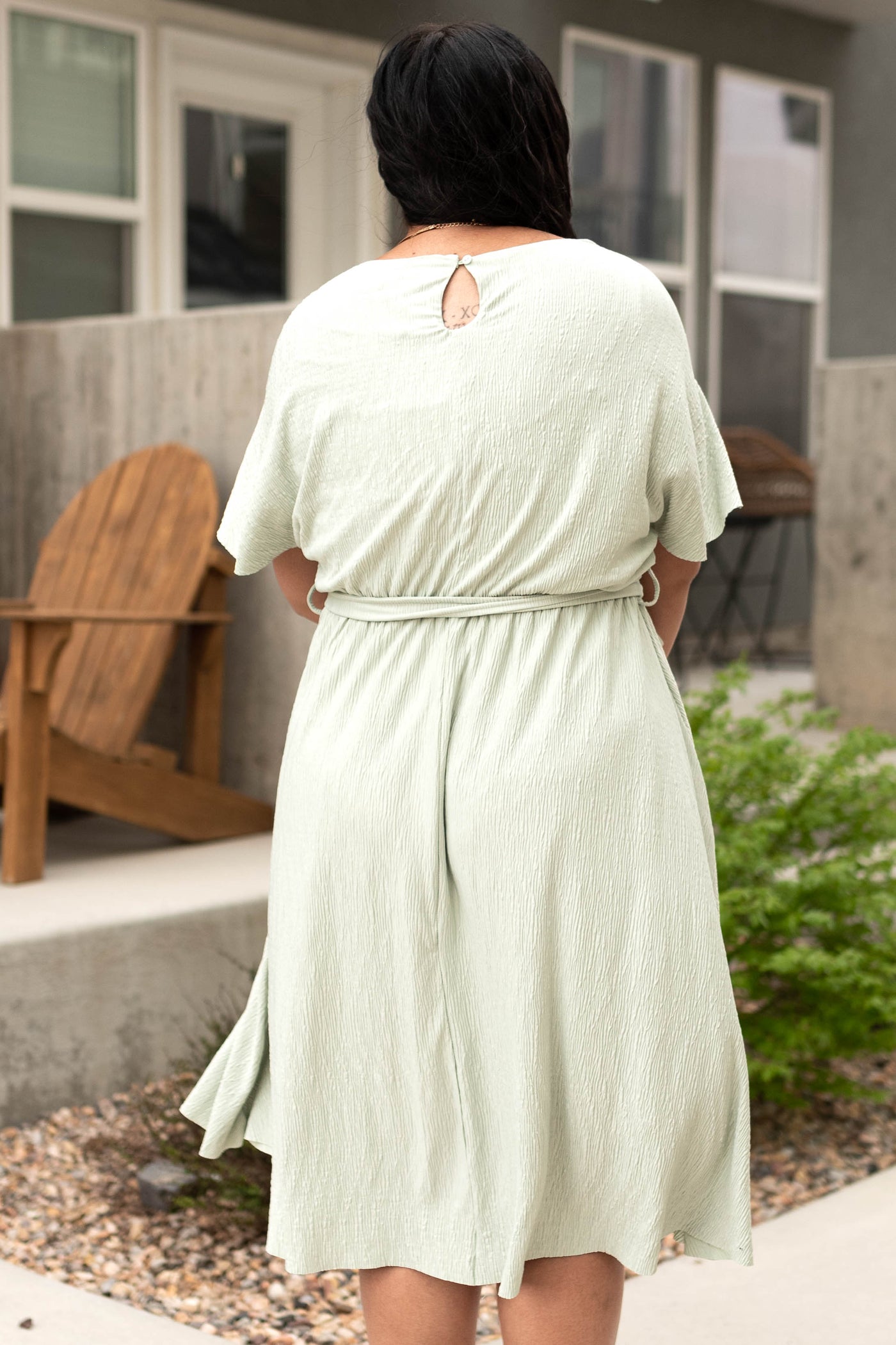Back view of a plus size short sleeve sage dress