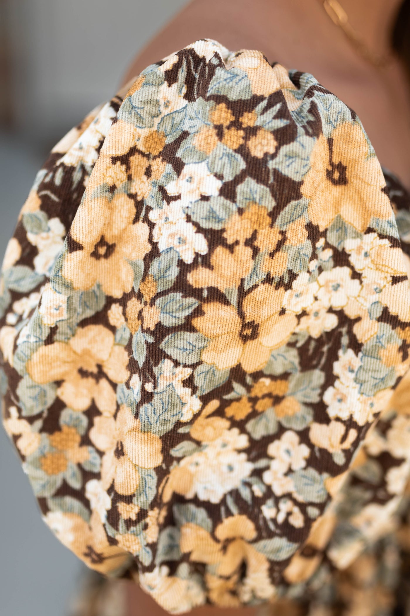 Sleeve view of a brown floral dress