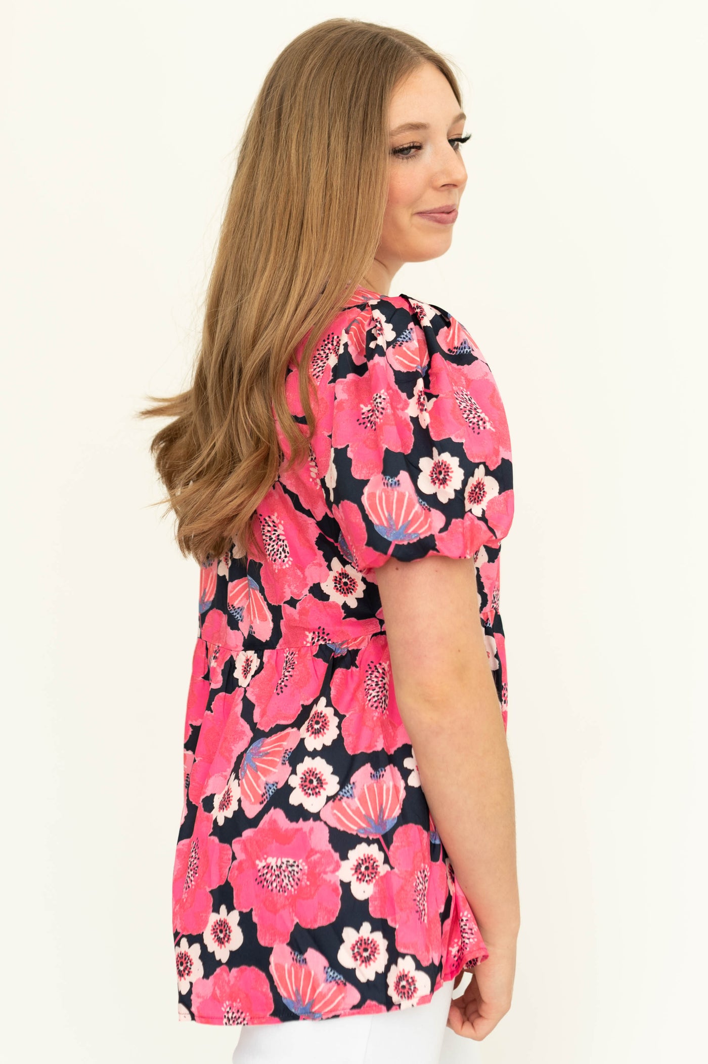 Sife view of a short sleeve deep pink floral top.