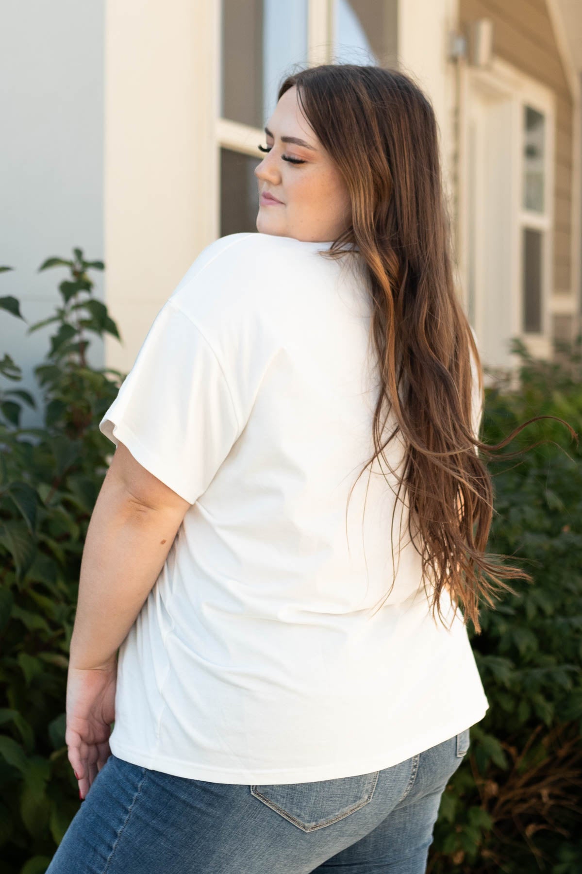Side view of a the stay wild and free ivory tee