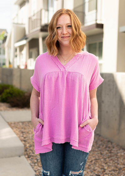 mauve short sleeve top with a v-neck and pockets.