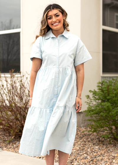 Front view of a blue button up dress with a collar