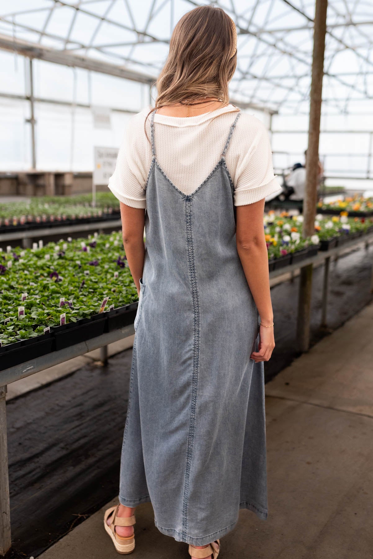 Back view of the denim blue overall dress with adjustable straps 