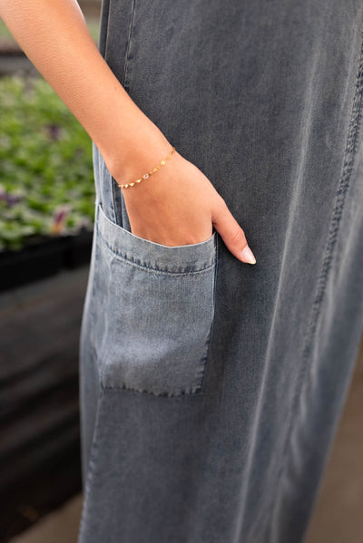 A view of the pocket on the denim blue overall dress