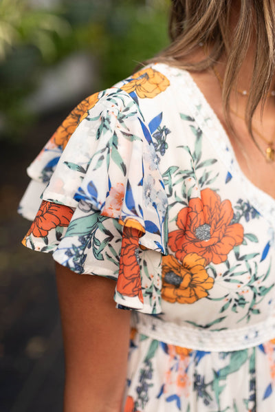 Close up of the fabric on the sleeve of the cream floral tiered dress