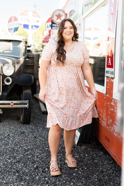 Plus size taupe floral dress with short sleeves.