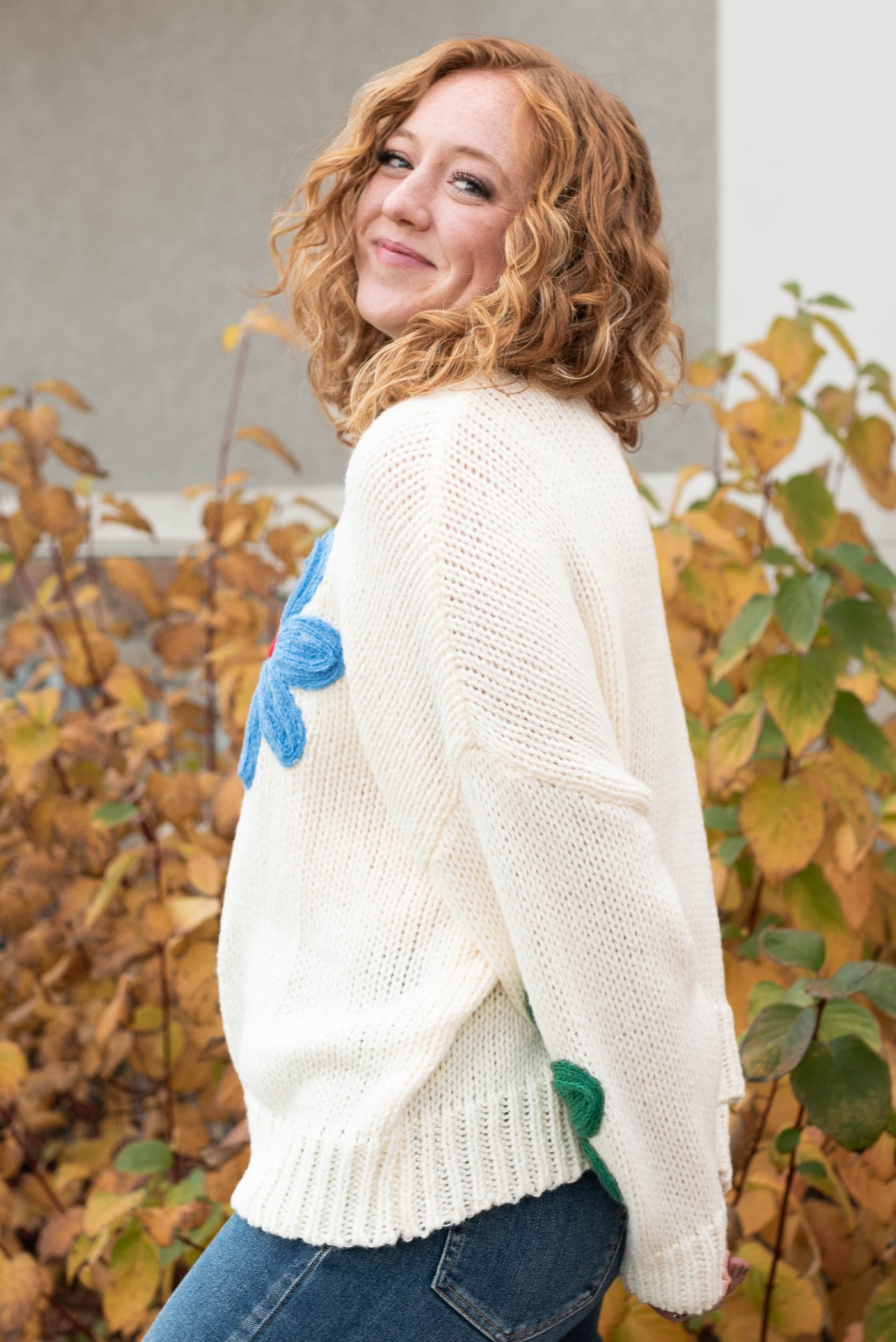 Side view of the cream flower sweater