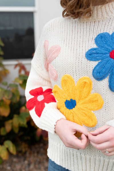 Close up of the flowers on the cream flower sweater
