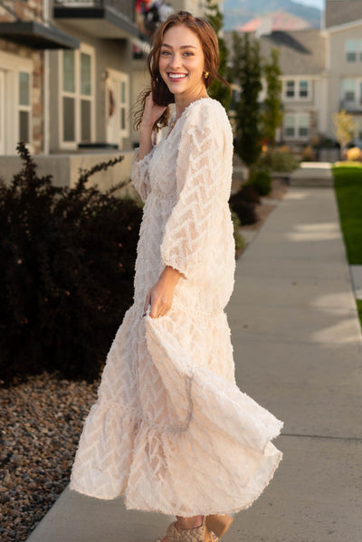 Side view of a long sleeve cream dress