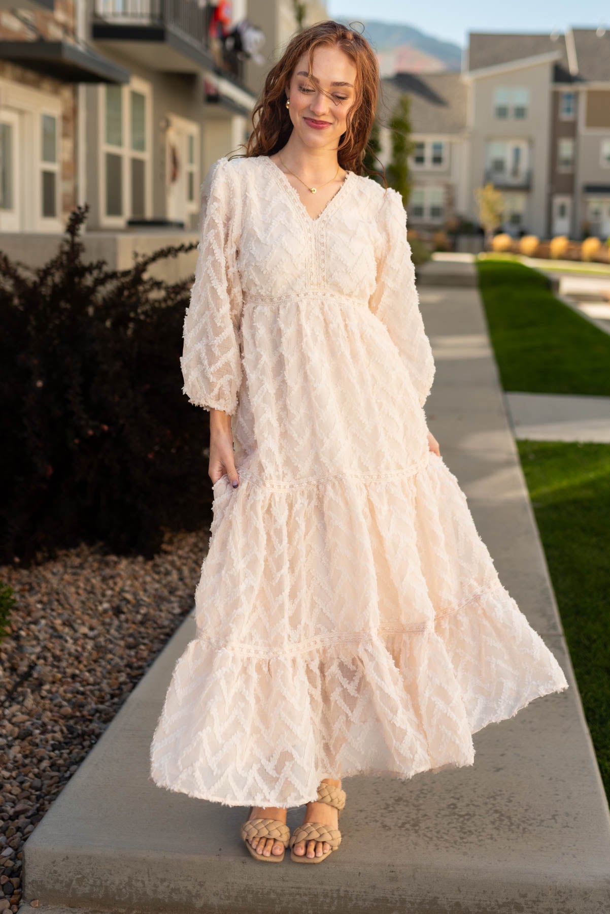Textured fabric long sleeve cream dress with tiered skirt