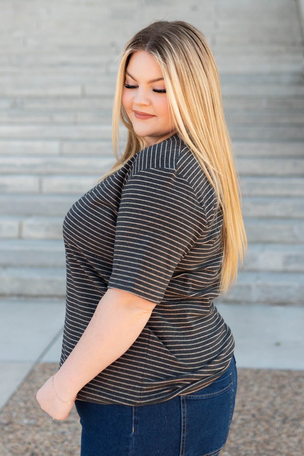 Side view of the plus size charcoal stripe top