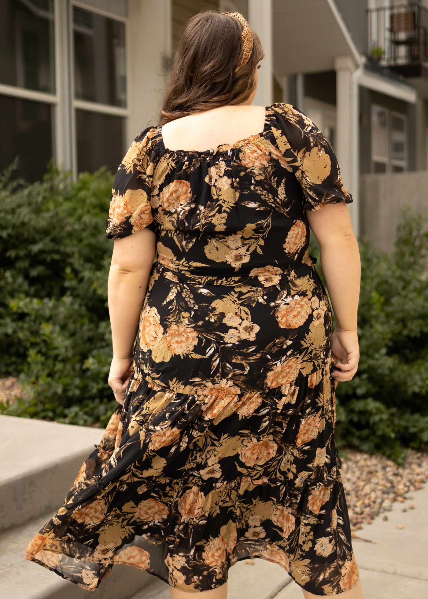 Back view of a plus size black floral dress
