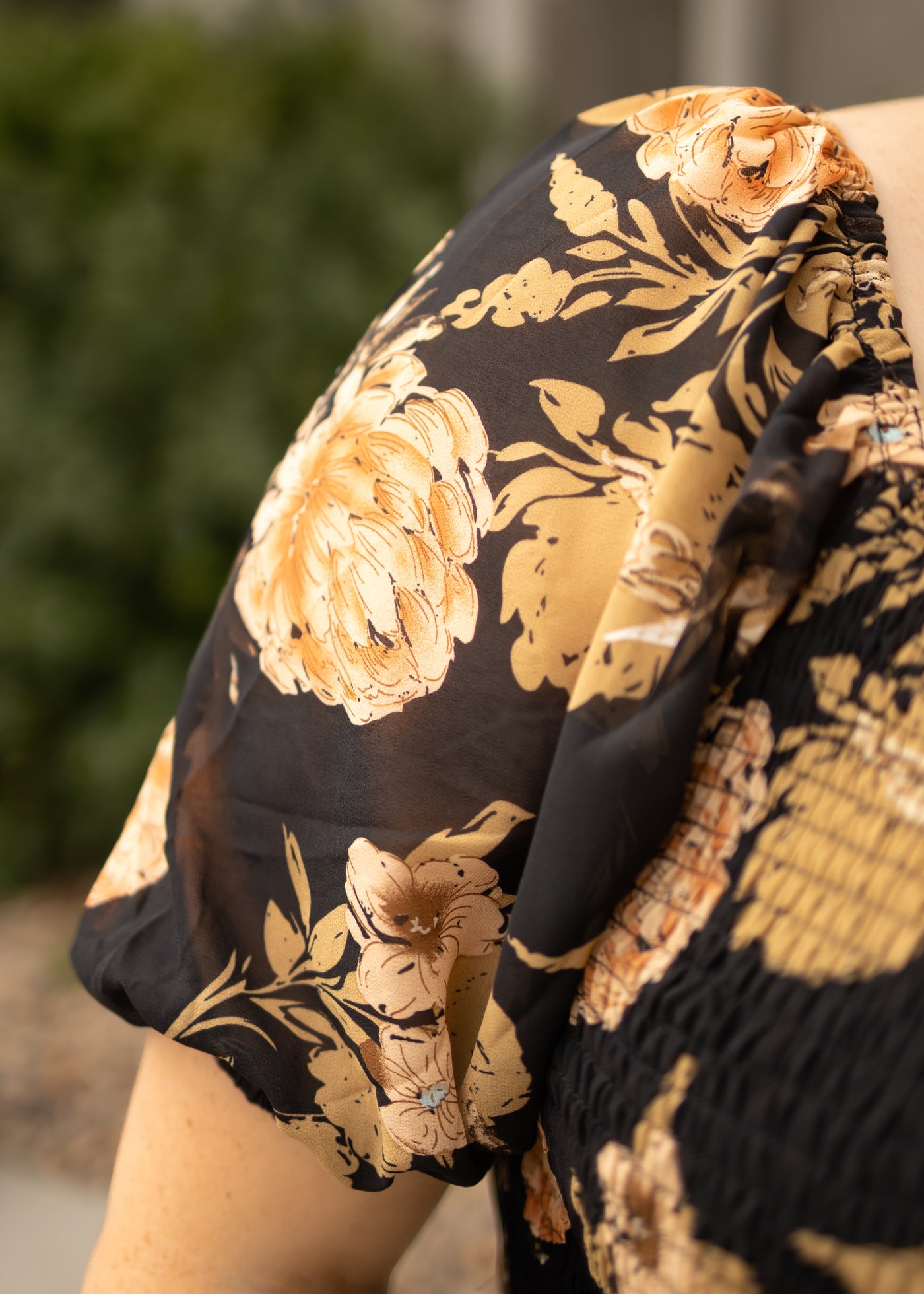 Sleeve view of a plus size black floral dress