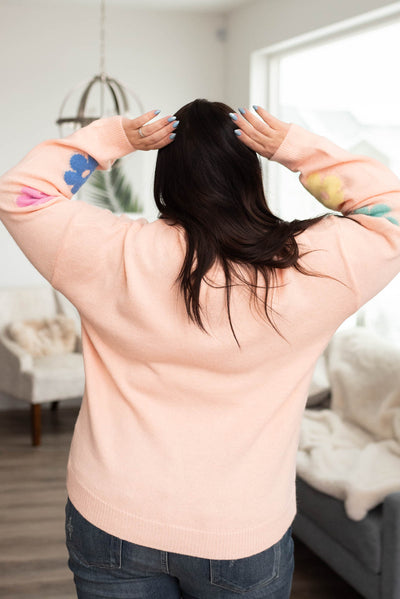 Back view of a blush floral sweater