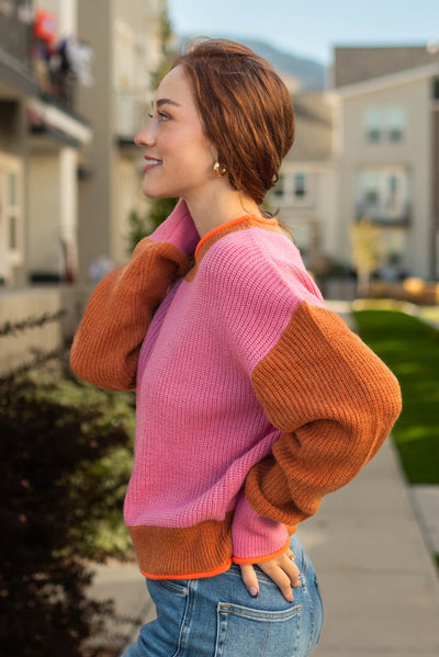 Side view of a color block pink sweater