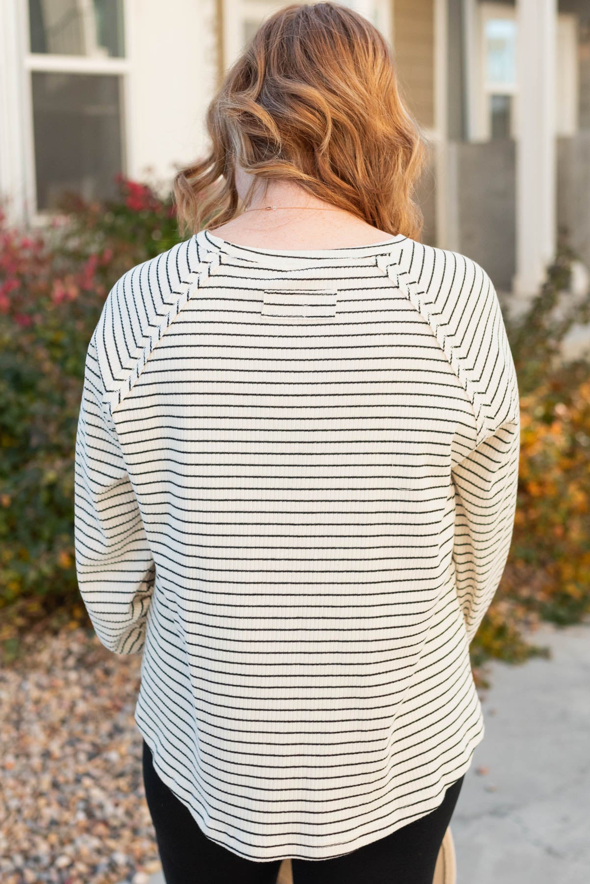 Back view of an ivory ribbed long sleeve top