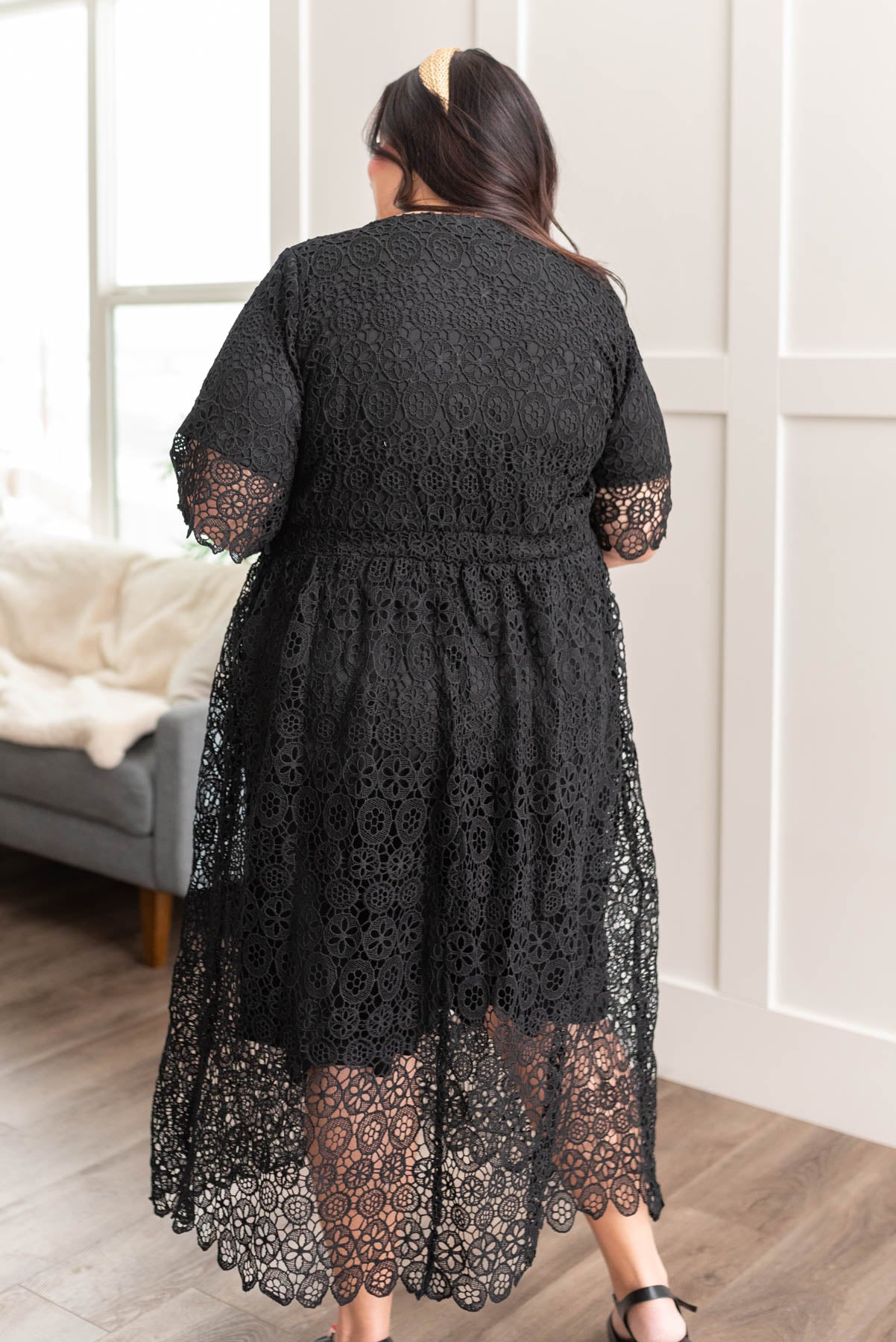 Back view of a plus size black lace dress