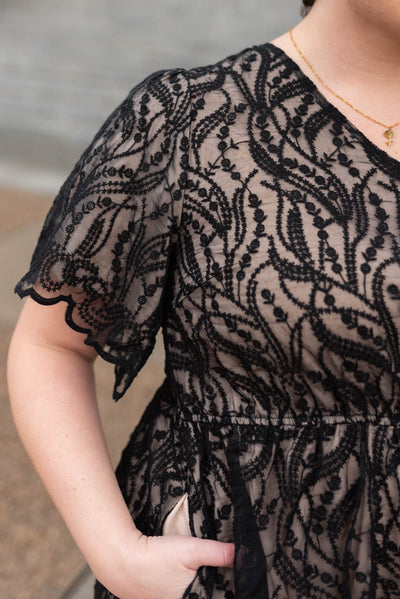 Close up of the lace fabric of a plus size black dress