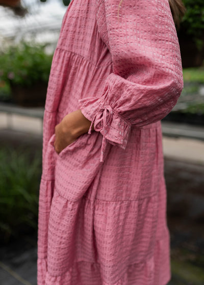 Close up of the fabric and pocket on the pink long sleeve dress
