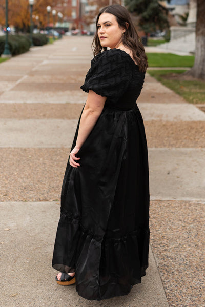 Side view of a plus size black organza dress with short sleeves