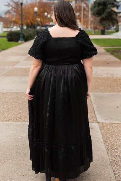 Back view of a plus size black organza dress