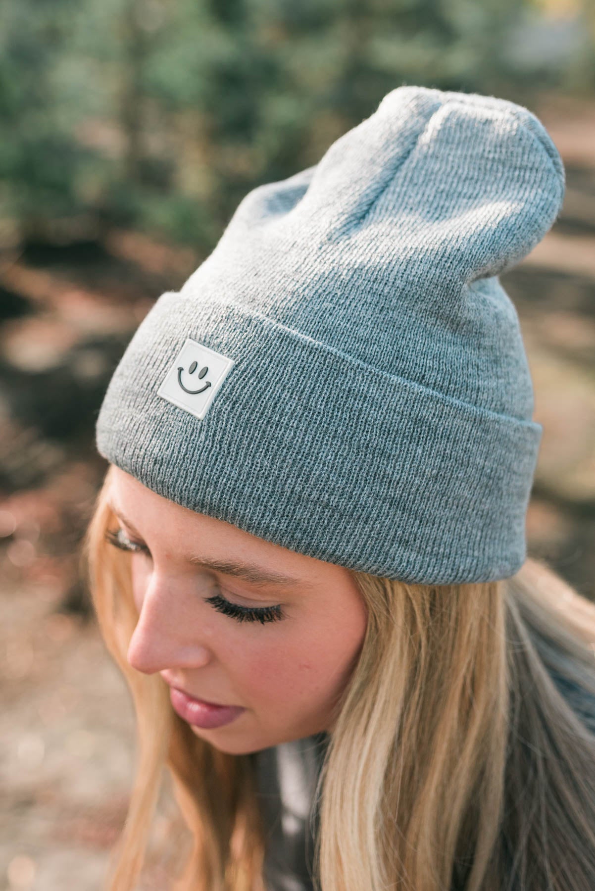 Side view of a heather grey smiley beanie